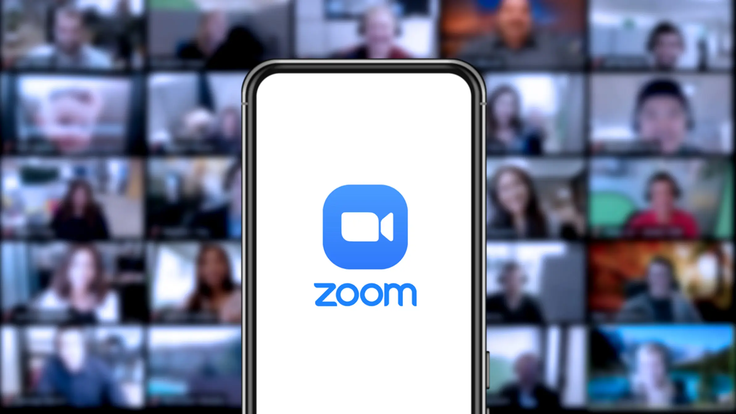 Zoom-logo-on-a-smartphone-with-a-video-call-in-the-background